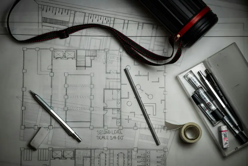 Architectural blueprints with drafting pencils and a ruler